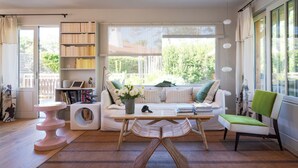 A cozy living room with a sofa, a coffee table, a bookshelf, and a chair. - La Giovanna - Villa 5bed, heated pool, pine garden, Cap-Ferret (Lège-Cap-Ferret)