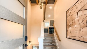 Een trap met houten treden en een moderne lamp erboven.