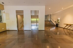 Eine geräumige Lobby mit moderner Treppe, einer Topfpflanze und minimalistischem Design.