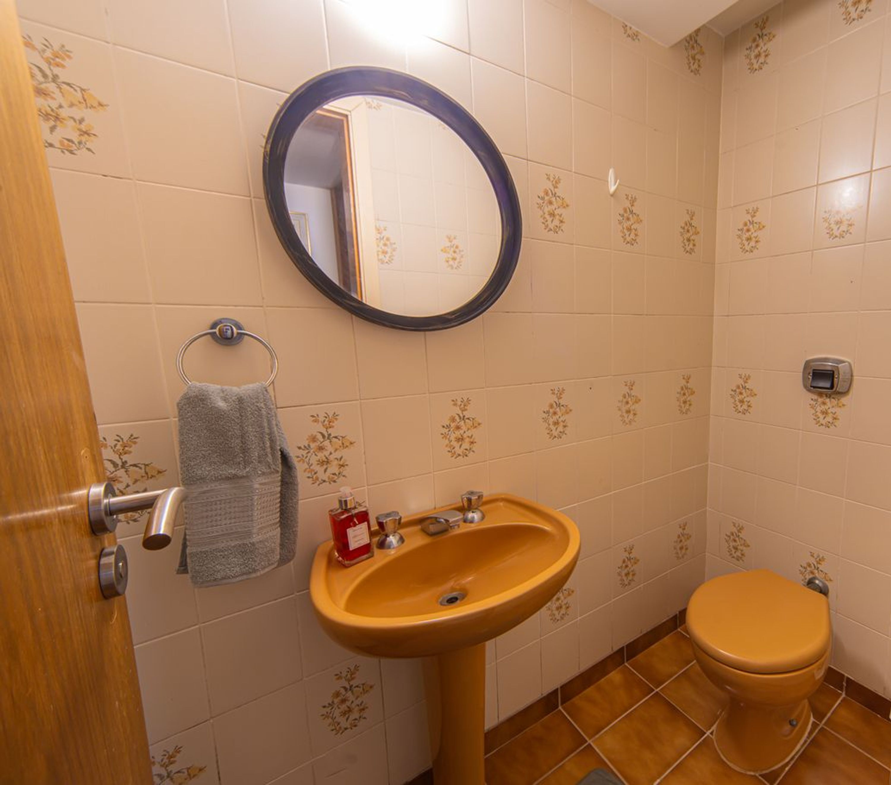 Un baño con lavamanos, inodoro y espejo.