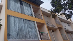 Um edifício de vários andares com uma placa indicando 'URBAN STAY', com quartos com e sem ar condicionado.