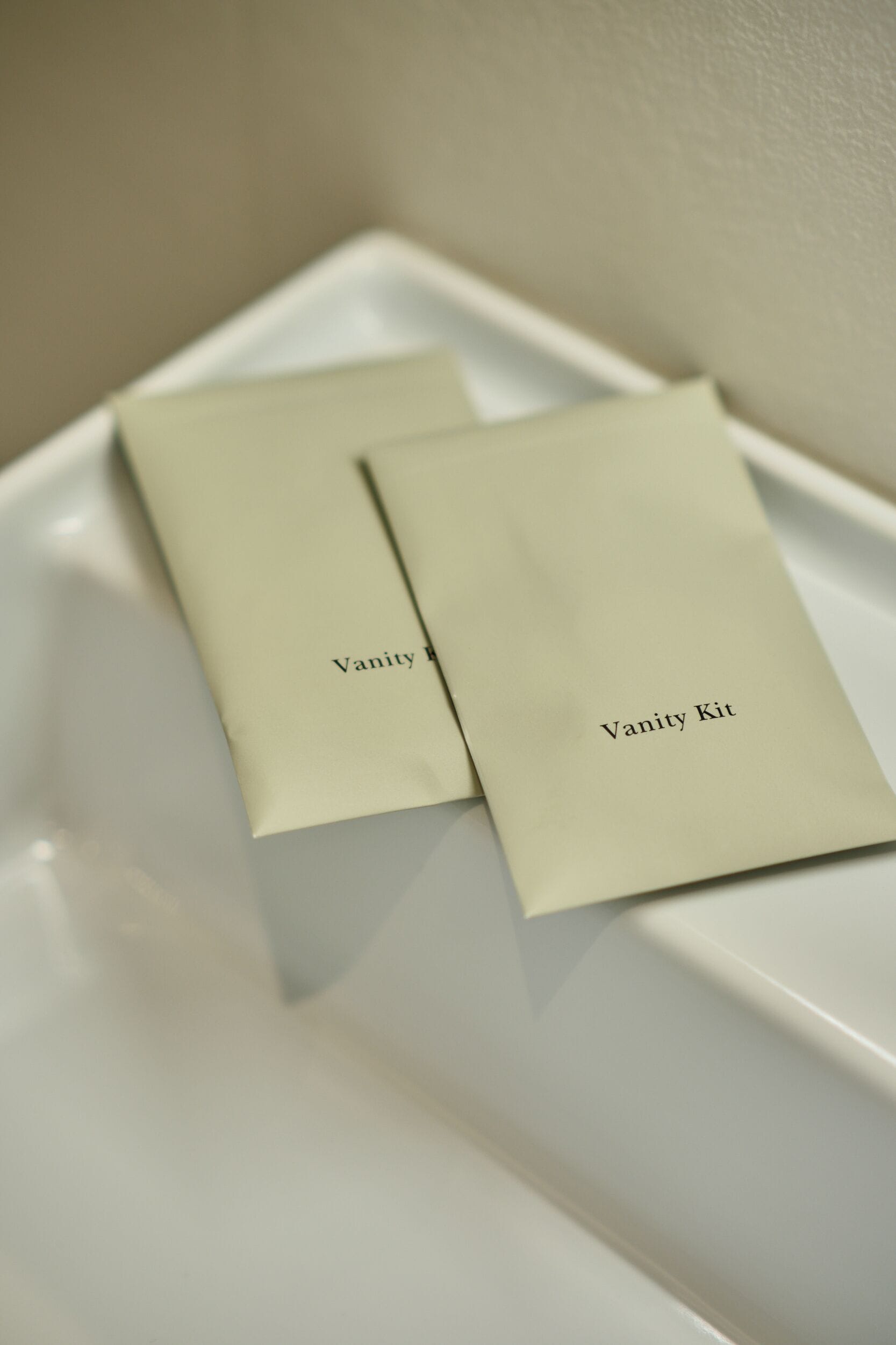 Two white rectangular objects with 'Vanity Kit' text on them, placed on a white surface.