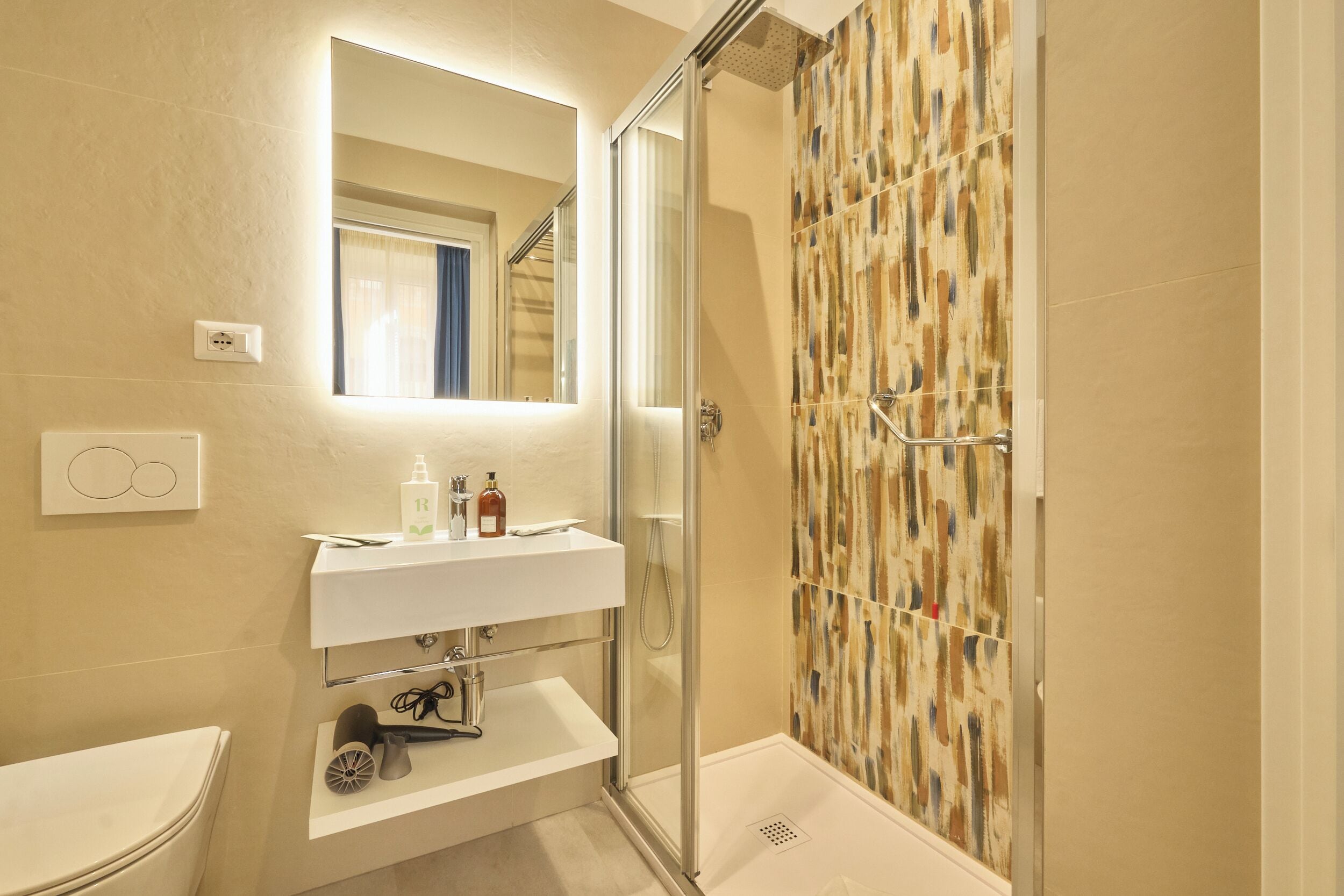 A bathroom with a glass-enclosed shower, a white sink with a mirror above it, and a towel rack.