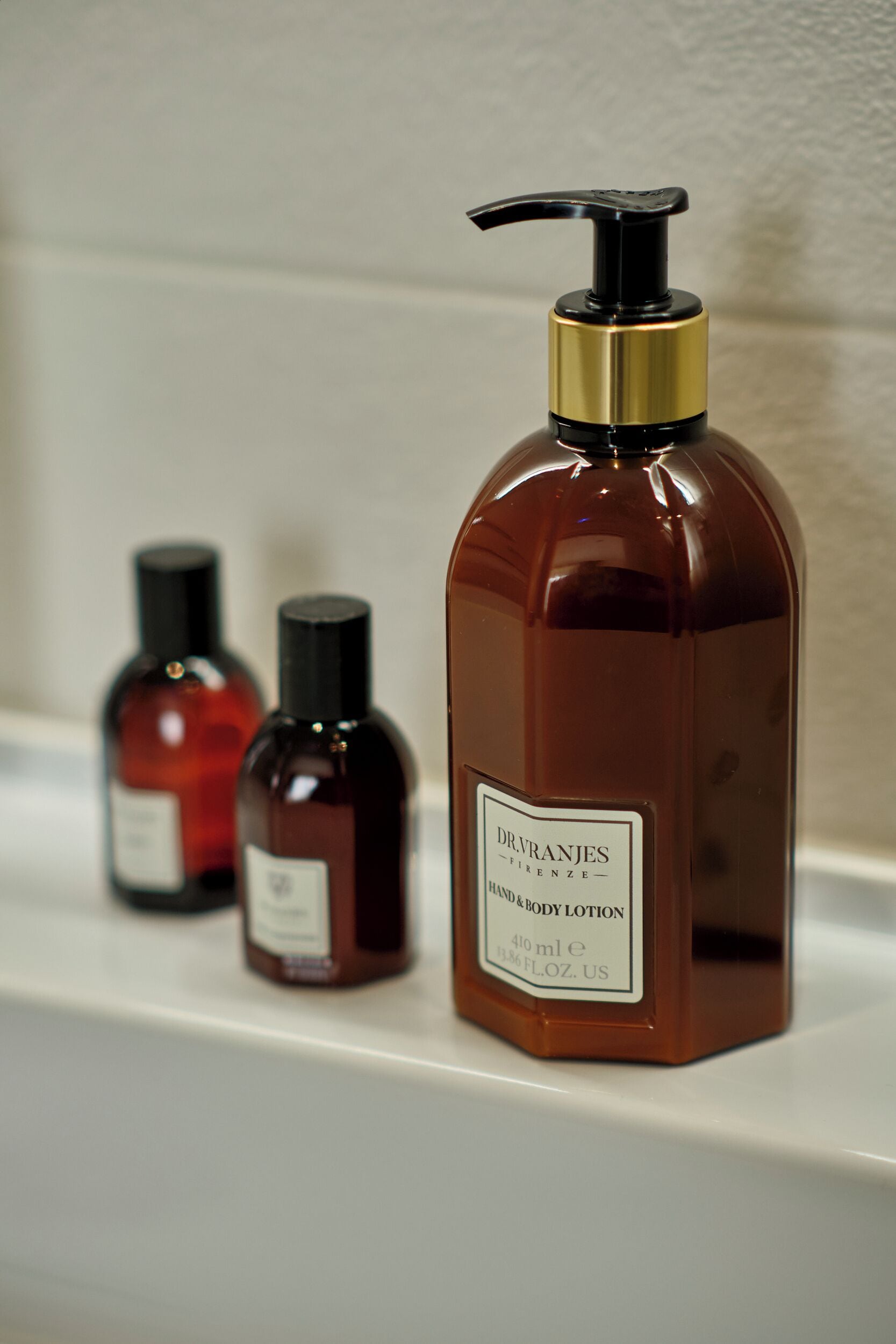 Three bottles of Dr. Van Riejenjes hand and body lotion on a shelf.