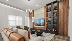 Una sala de estar moderna con un sofá, una mesa de centro y un televisor montado en la pared.