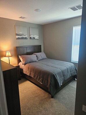 A bedroom with a bed, a nightstand, a lamp, and two wall-mounted pictures. - Fully furnished home in Converse, it's nice, convenient and a quiet stay. (Converse)