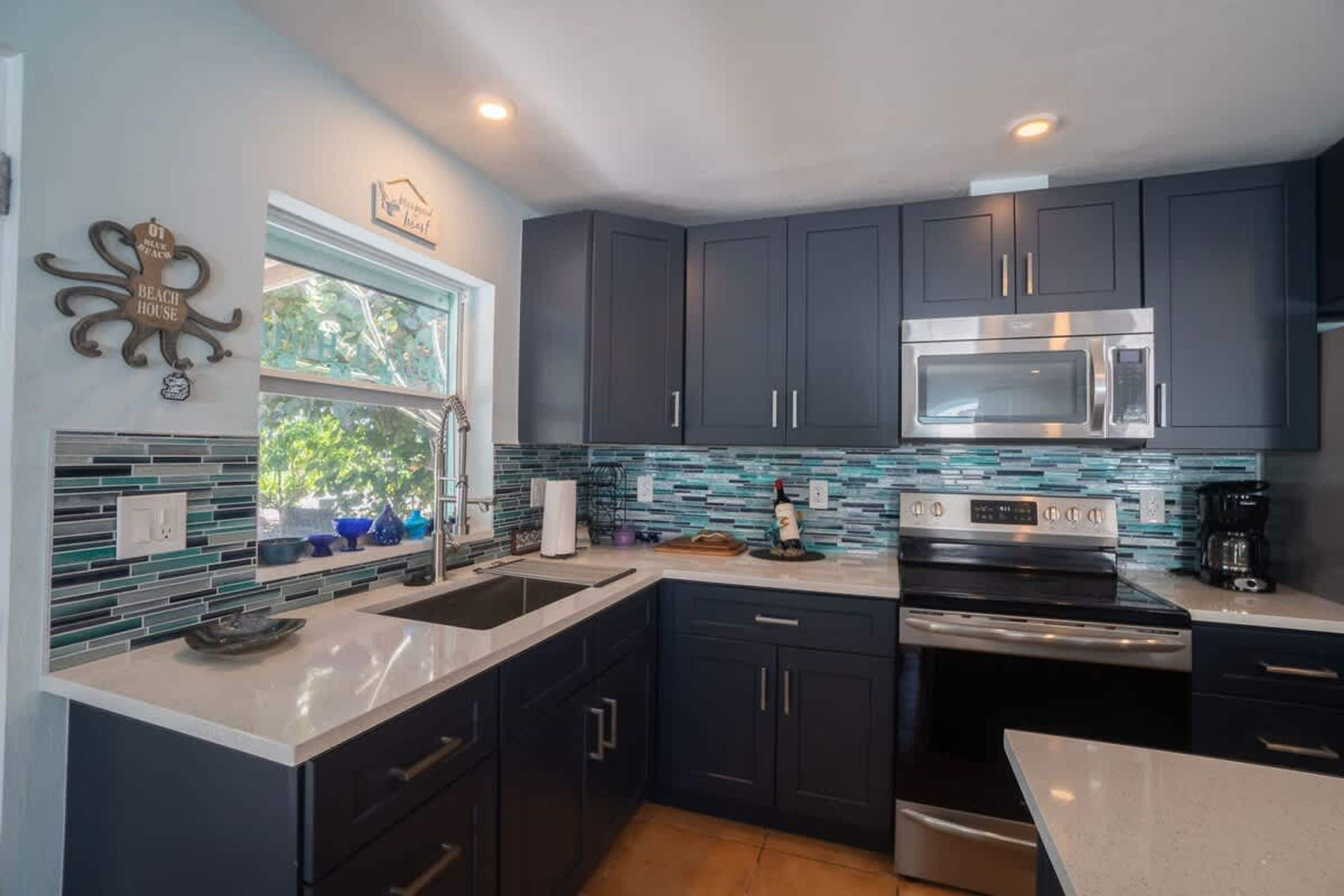 A modern kitchen with dark cabinets, a stainless steel microwave, and a built-in oven.
