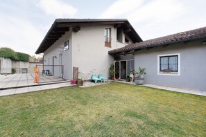 A two-story house with a patio, a basketball hoop, and a small garden area. - Studio 'Luna' with Shared Garden, Balcony and Wi-Fi (Monforte d'Alba)