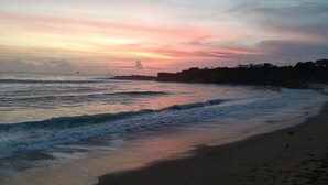 A beach with waves, a sunset, and a rocky coastline. - Room-lisbon Nice & Cousy Room (Lisbon)