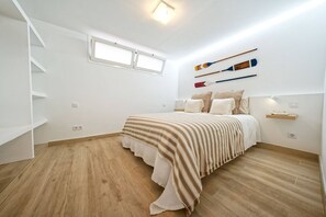 A bedroom with a bed, a window, a wall-mounted shelf, and a staircase. - Royal Blue San Agustin (San Bartolomé de Tirajana)