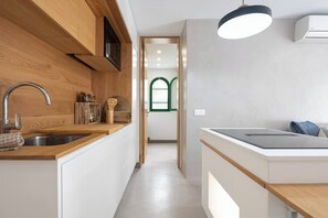 Eine moderne Küche mit Holzarbeitsplatte, Edelstahlspüle und eingebautem Herd.