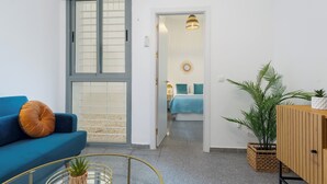 Un salon moderne avec un canapé bleu, une table basse et une plante en pot.