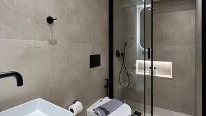 A modern bathroom with a glass-enclosed shower, a white sink, and a toilet. - BlueMotion - CruiseNest Single  (Piraeus)