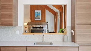 A kitchen with a stone fireplace, wooden cabinets, and a countertop.