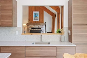 A kitchen with a stone fireplace, wooden cabinets, and a countertop.