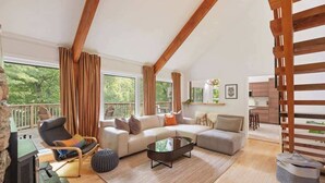 A spacious living room with a sofa set, a coffee table, a TV, and a fireplace.