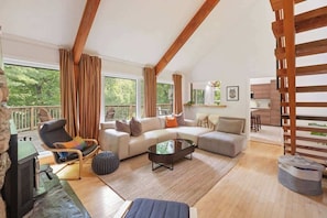 A spacious living room with a sofa set, a coffee table, a TV, and a fireplace.