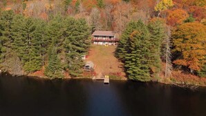 A lodge surrounded by a forest with a lake in front. - KilDrummy Cottage with Sauna (Calabogie)