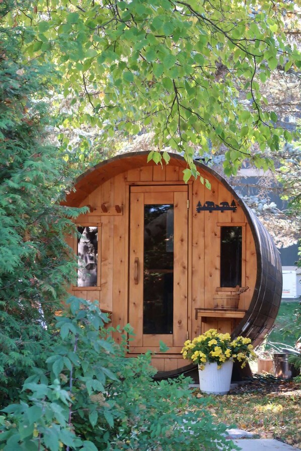 Une cabane en bois avec un toit incurvé, une porte et des fenêtres.