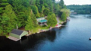 A lakeside cabin with a dock, surrounded by dense forest. - Loggers Lodge an Anglers Retreat (Calabogie)