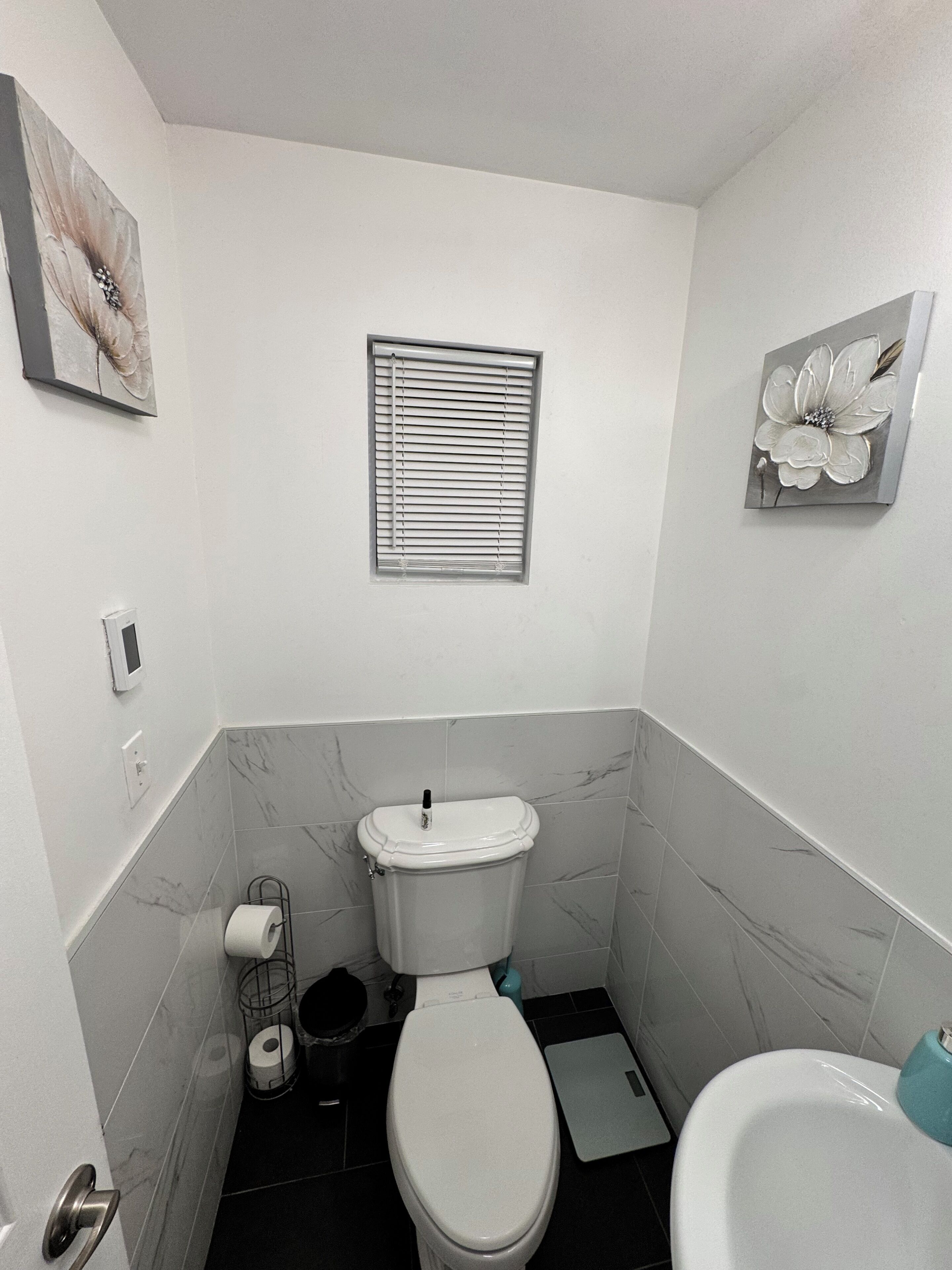 A compact bathroom with a toilet, bidet, and a small window.