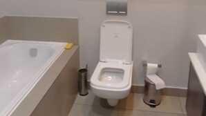 A bathroom with a toilet, bidet, and a bathtub. - The Empire Inn (Serowe)