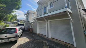 A residential building with a garage, a balcony, and a driveway.