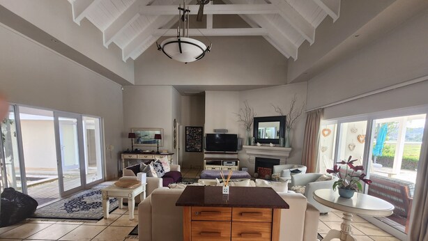 A spacious living room with a fireplace, a television, and a dining area with a table and chairs.