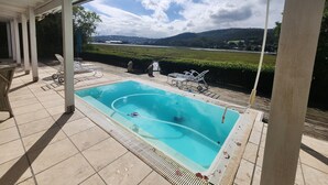 A covered outdoor swimming pool with a view of a distant landscape.