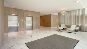 A modern lobby with elevators, a reception desk, and seating area. - Areeiro Vision Studio by Homing (Lisbon)