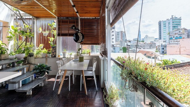 A balcony with a dining area, potted plants, and a city view. - Cozrum - Idea Apartment (Ho Chi Minh City)