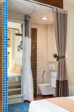 Une salle de bain avec douche, toilettes et lavabo.