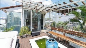 A rooftop terrace with a glass enclosure, a small pool, and potted plants. - Cozrum - Idea Apartment (Ho Chi Minh City)