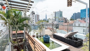 A rooftop terrace with a view of the city skyline, including a prominent tower. - Cozrum - Idea Apartment (Ho Chi Minh City)