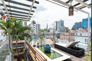 Terraço no telhado com vista para o horizonte da cidade, incluindo uma torre imponente.