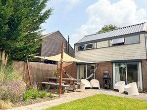 Outdoor dining - Strandbries is a bright and serene holiday home in Warmenhuizen, close to the beach, dunes and forest of Schoorl, Bergen and Petten. Featuring a wooden floor, sunny garden, Green Egg and slow-living vibe. Perfect for families and nature lovers. (Warmenhuizen)