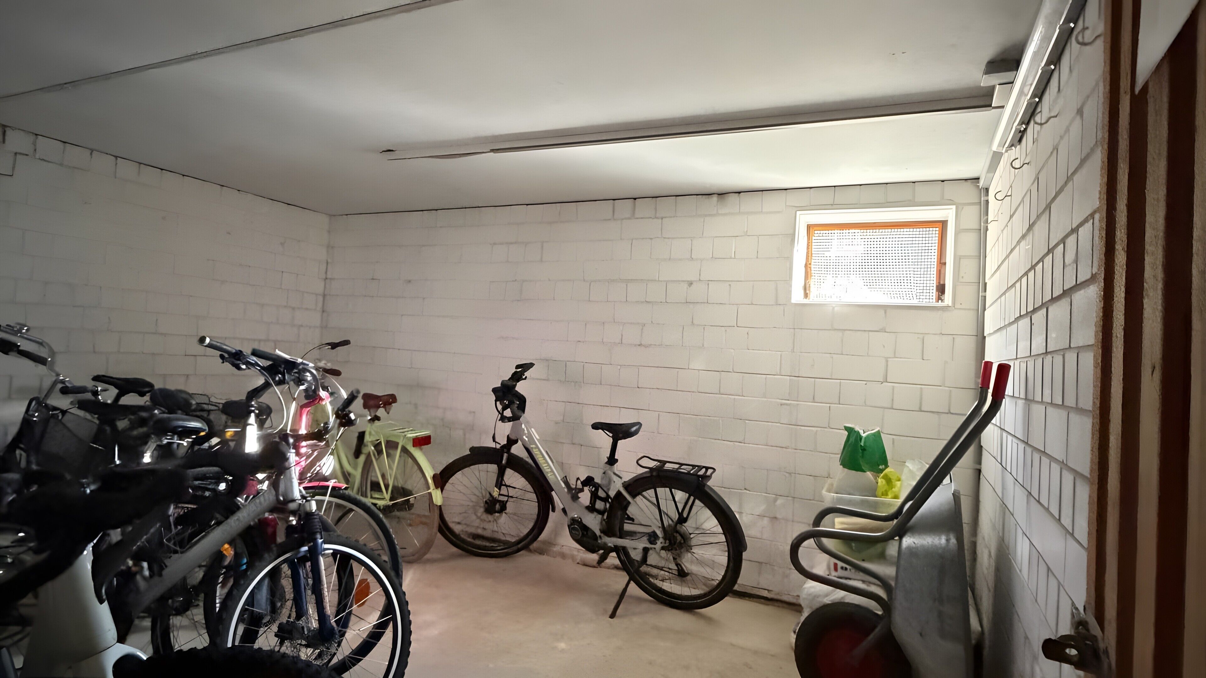 Eine Garage mit Fahrrädern, einem Fenster und einer Tür.