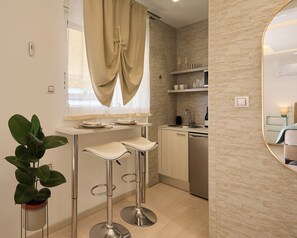 Eine moderne Küche mit Barhocker, Topfpflanze, Spüle und einer Weinflasche.