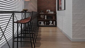 A modern interior with a long bar area, wooden flooring, and a brick wall. - PREMIUM DOO Hostel (Tashkent)