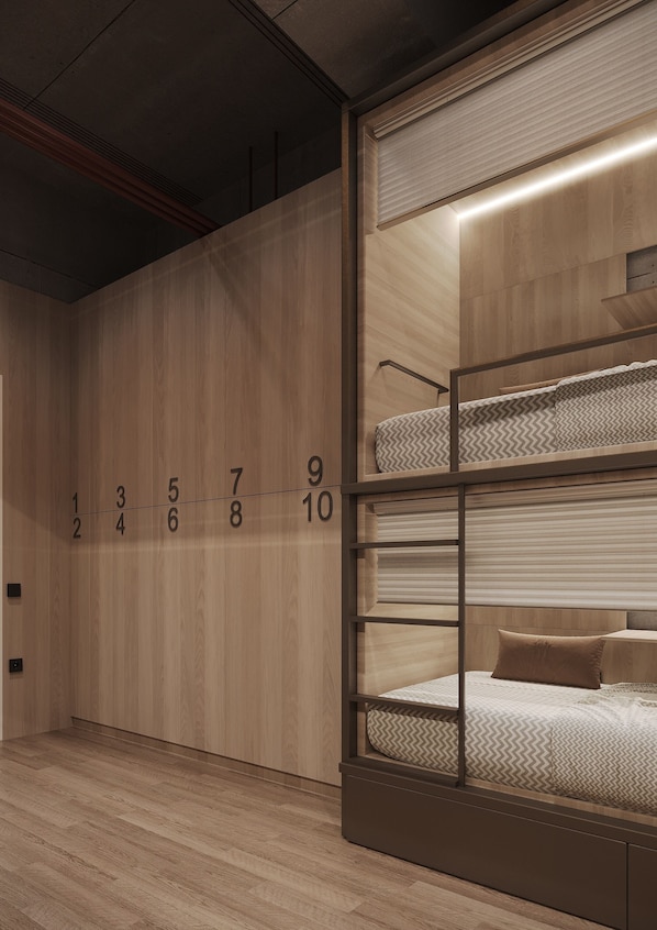 Una cama individual en literas con un panel de madera y puertas de habitaciones numeradas.