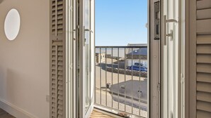 Ein Balkon mit Blick auf einen Parkplatz und ein Gebäude mit Steinmauern.