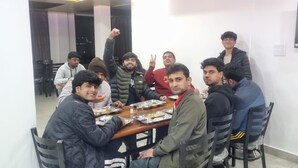 A group of people seated around a wooden table in a room with a white wall and a flat-screen TV mounted above. - Your home away from home in mountains / 1-bedroom bed & breakfast (Rampur)