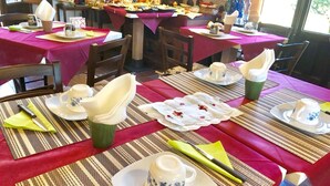 Een eetgedeelte met gedekte tafels, inclusief placemats, servetten en bestek.