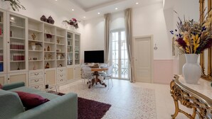 Ein modernes Wohnzimmer mit Sofa, Fernseher, Bücherregal und Dekorationselementen.