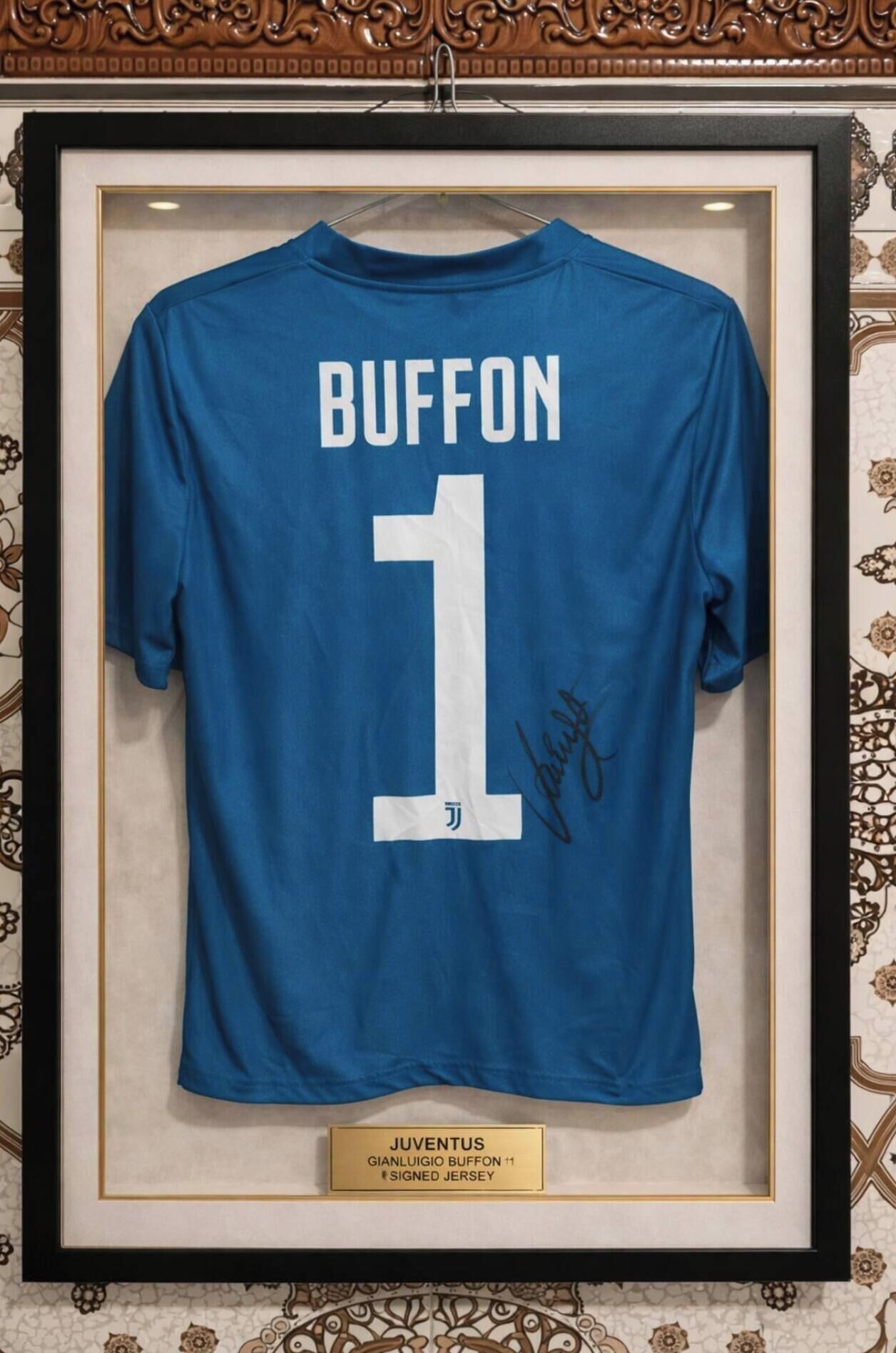 Un maillot de la Juventus encadré, portant le nom « BUFFON » et le numéro « 1 » dans le dos, et autographié par le joueur.