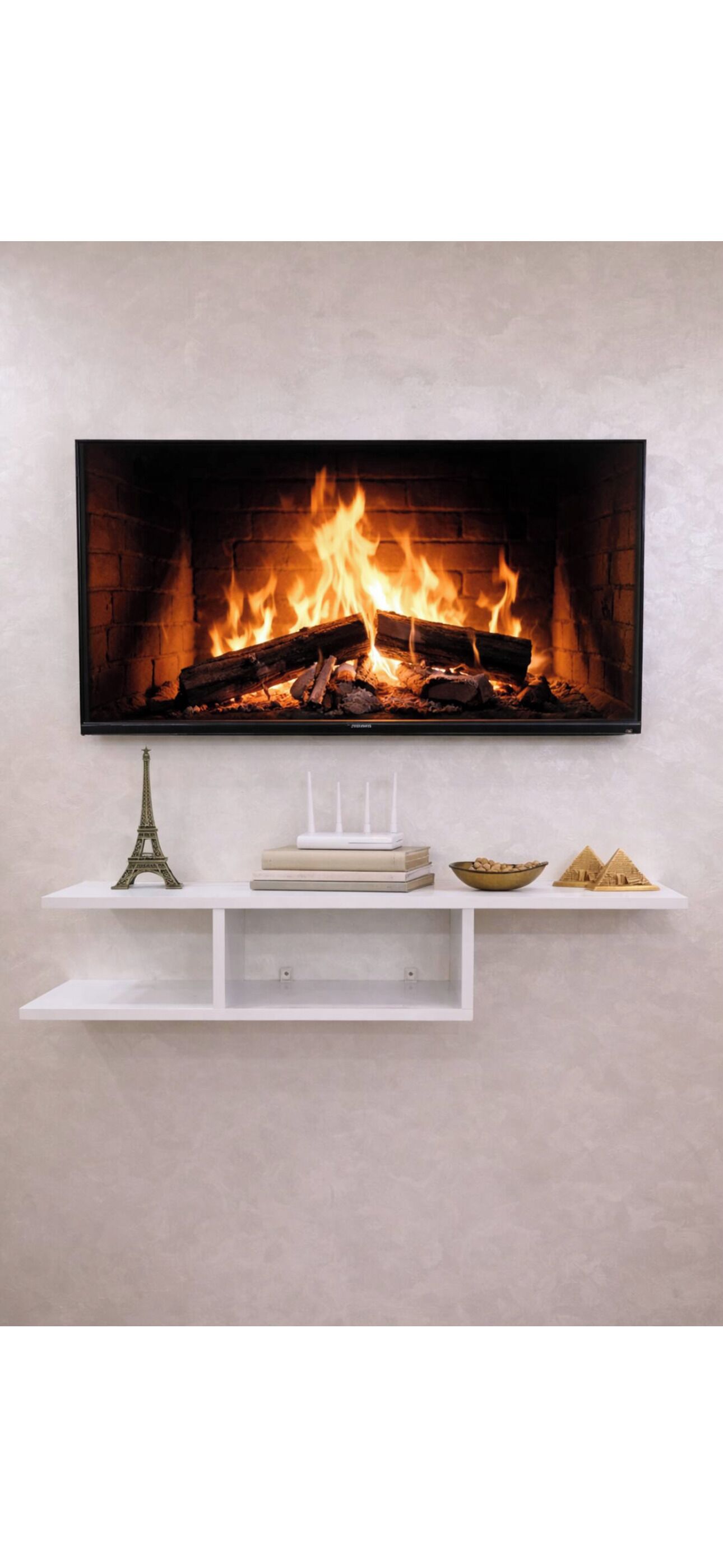 Un téléviseur à écran plat fixé au mur, au-dessus d’une étagère blanche ornée d’objets décoratifs.