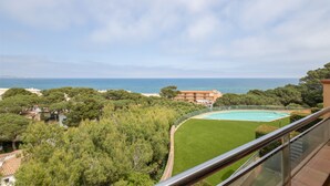 A view of a coastal property with a swimming pool, lush greenery, and a distant view of the sea. - Apartment 'Sa Calma I - 1A' with Sea View, Wi-Fi and Air Conditioning (Begur)