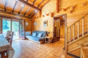 Un intérieur en bois avec un canapé, une table et un escalier.
