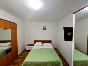 A room with a bed, a nightstand, a mirror, and a small picture on the wall. - Studio Apartment Vita (Nin)
