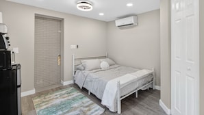 A bedroom with a bed, a white wardrobe, a door, and a ceiling light. - Cozy Beach Studio • Walk to the Sand (Pompano Beach)